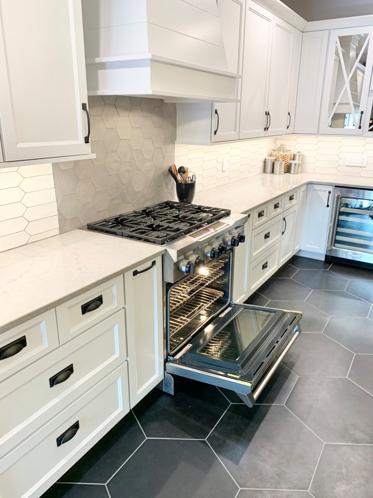 Large transitional l-shaped eat-in kitchen in Other with a farmhouse sink, recessed-panel cabinets, white cabinets, quartz benchtops, multi-coloured splashback, ceramic splashback, stainless steel appliances, ceramic floors, with island, black floor and white benchtop.