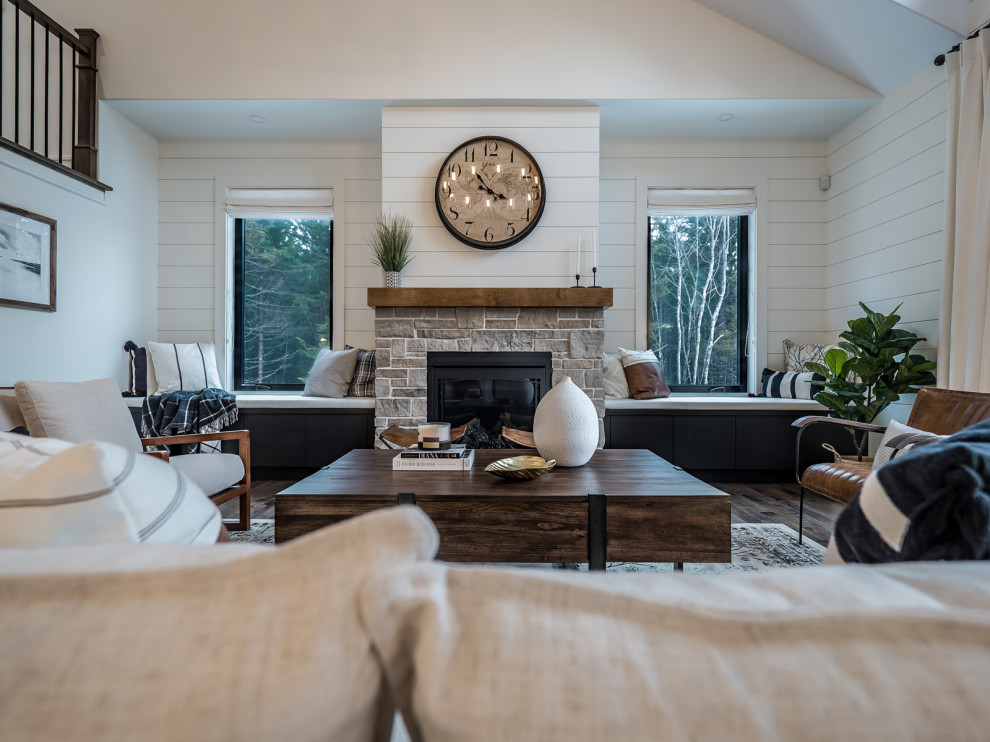This is an example of a large country open concept living room in Other with white walls, dark hardwood floors, a standard fireplace, a stone fireplace surround and no tv.