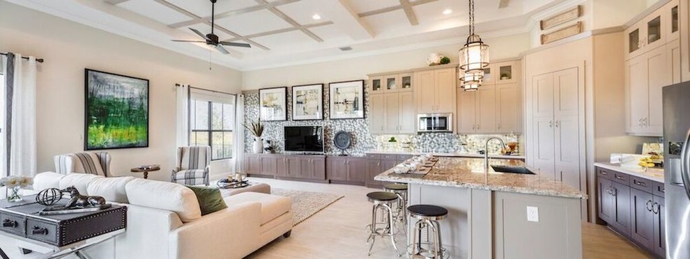 Inspiration for a large transitional l-shaped light wood floor open concept kitchen remodel in Miami with an undermount sink, shaker cabinets, beige cabinets, granite countertops, metallic backsplash, mosaic tile backsplash, stainless steel appliances and an island