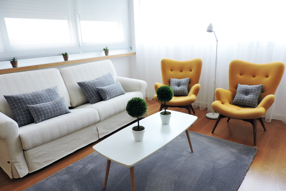 Imagen de sala de estar cerrada escandinava de tamaño medio con paredes blancas y suelo de madera en tonos medios