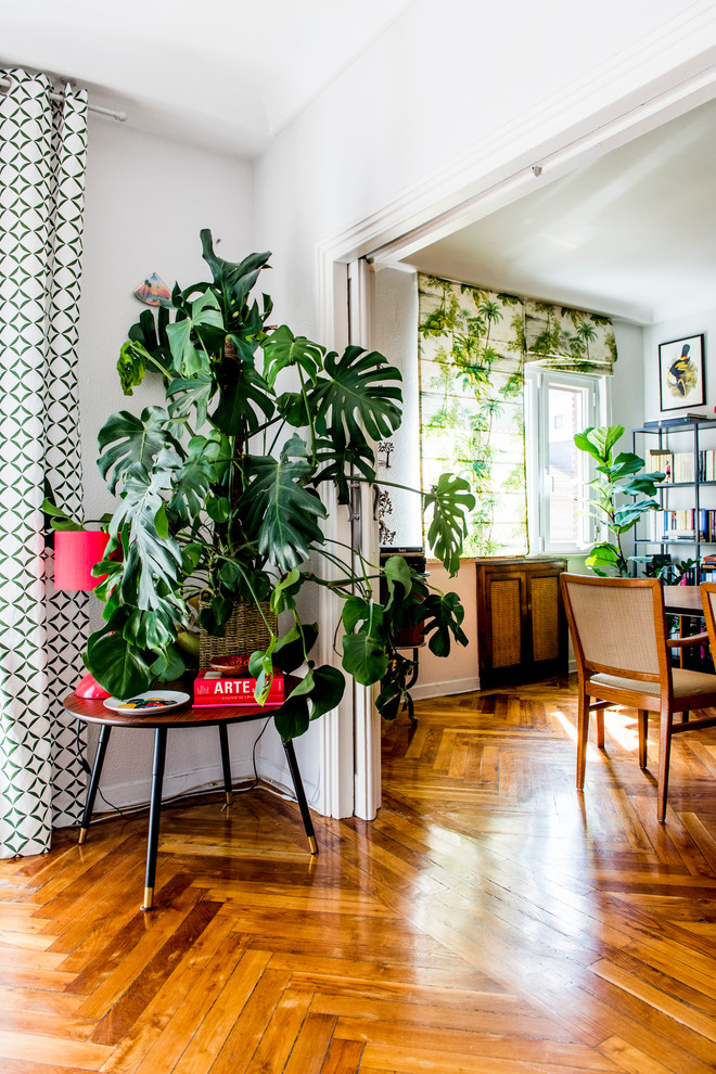 Mid-sized tropical hallway in Madrid with white walls and medium hardwood floors.