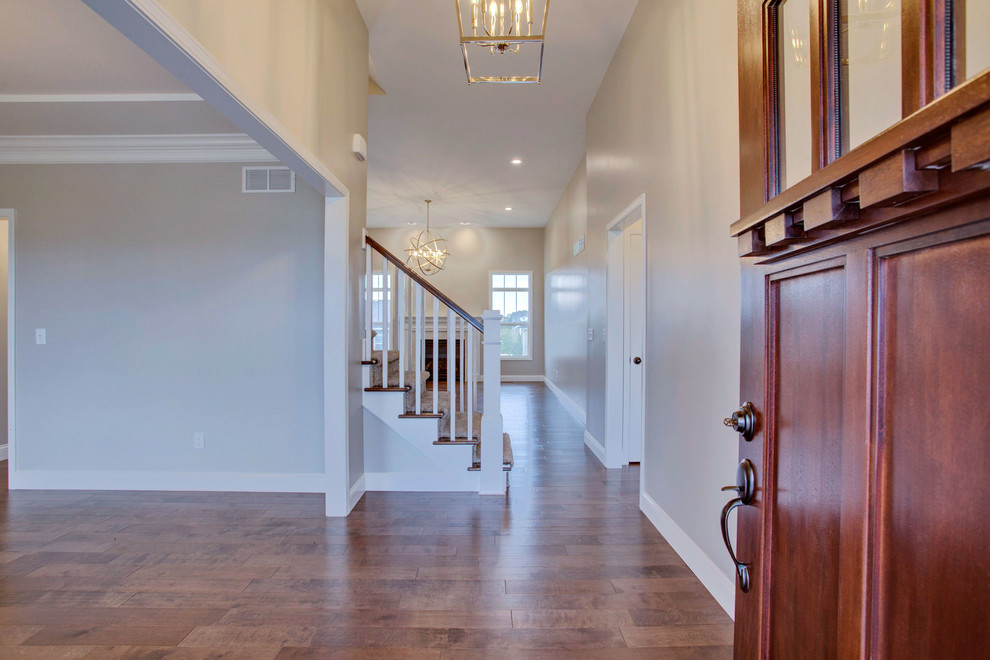 Foyer - mid-sized transitional medium tone wood floor foyer idea in Chicago with gray walls and a dark wood front door