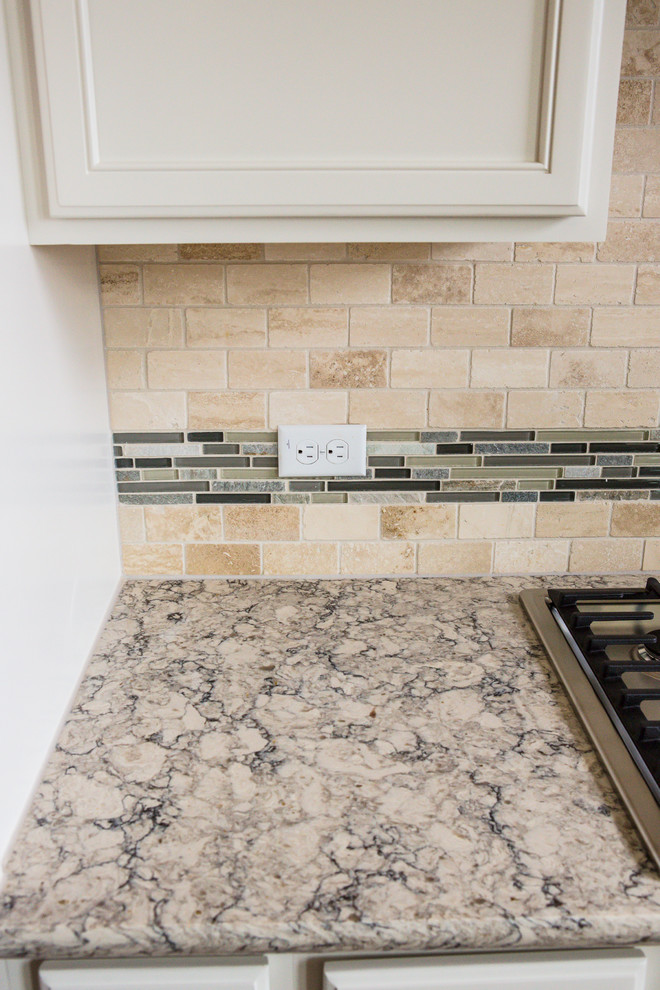 Example of a mid-sized transitional l-shaped medium tone wood floor eat-in kitchen design in Austin with an undermount sink, recessed-panel cabinets, white cabinets, granite countertops, beige backsplash, stone tile backsplash, stainless steel appliances and an island