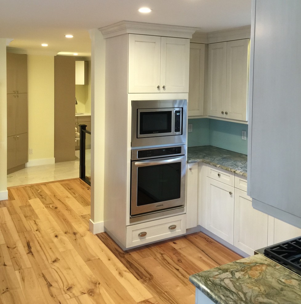 Inspiration for a mid-sized eclectic light wood floor kitchen remodel in Calgary with shaker cabinets, white cabinets, quartzite countertops, stainless steel appliances, an island and glass sheet backsplash