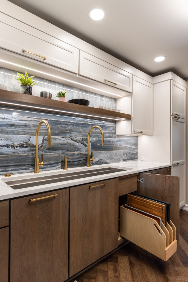 デトロイトにある高級な中くらいなコンテンポラリースタイルのおしゃれなキッチン (シングルシンク、フラットパネル扉のキャビネット、白いキャビネット、クオーツストーンカウンター、青いキッチンパネル、磁器タイルのキッチンパネル、シルバーの調理設備、クッションフロア、茶色い床、白いキッチンカウンター) の写真