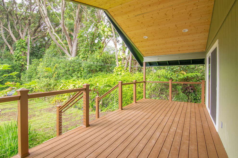 This is an example of a mid-sized arts and crafts backyard deck in Hawaii with a roof extension.