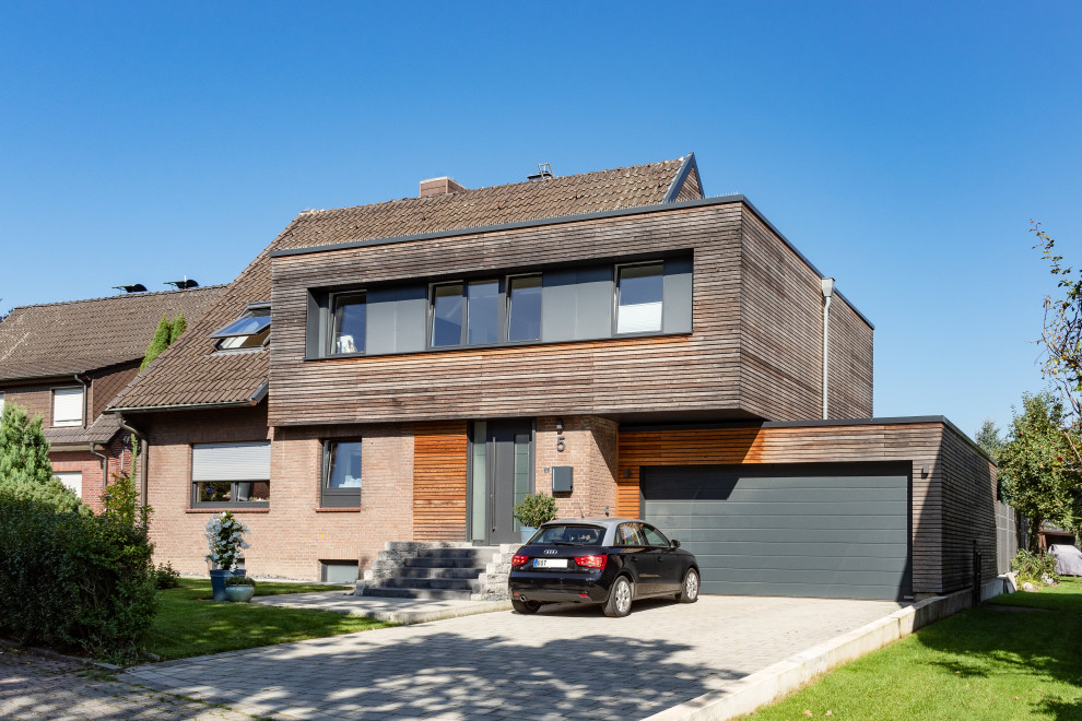 Cette image montre une façade de maison grise minimaliste en bois et bardage à clin de taille moyenne et de plain-pied avec un toit plat.