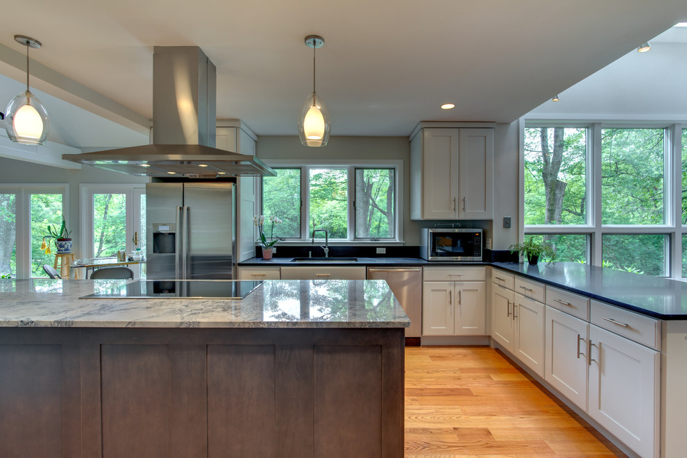 Photo of a large transitional l-shaped eat-in kitchen in Boston with an undermount sink, shaker cabinets, grey cabinets, granite benchtops, stainless steel appliances, medium hardwood floors and with island.