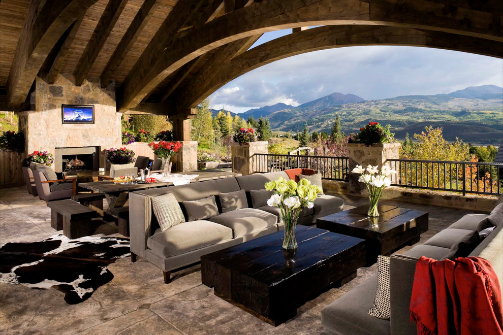 Inspiration for a huge rustic backyard deck remodel in Denver with a fire pit and a roof extension