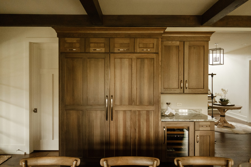 Open concept kitchen - large rustic u-shaped exposed beam open concept kitchen idea in Chicago with paneled appliances and an island