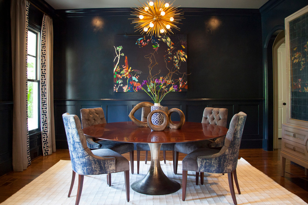 This is an example of a contemporary dining room in Charlotte with black walls and dark hardwood floors.
