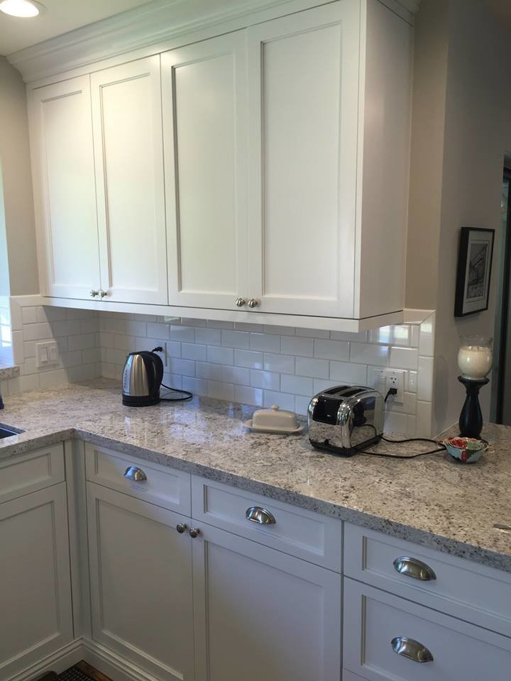 Large transitional medium tone wood floor kitchen photo in Phoenix with an undermount sink, shaker cabinets, white cabinets, granite countertops, white backsplash, subway tile backsplash, stainless steel appliances and an island