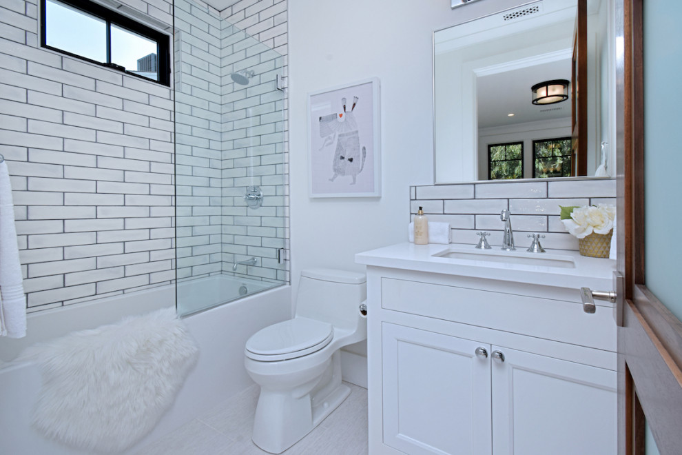 Example of a mid-sized farmhouse kids' white tile and subway tile porcelain tile, white floor and single-sink bathroom design in Los Angeles with flat-panel cabinets, white cabinets, a one-piece toilet, white walls, an undermount sink, solid surface countertops, white countertops and a built-in vanity