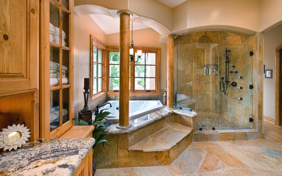 Expansive country bathroom in San Diego with raised-panel cabinets, medium wood cabinets, granite benchtops, an alcove shower, beige walls and slate floors.