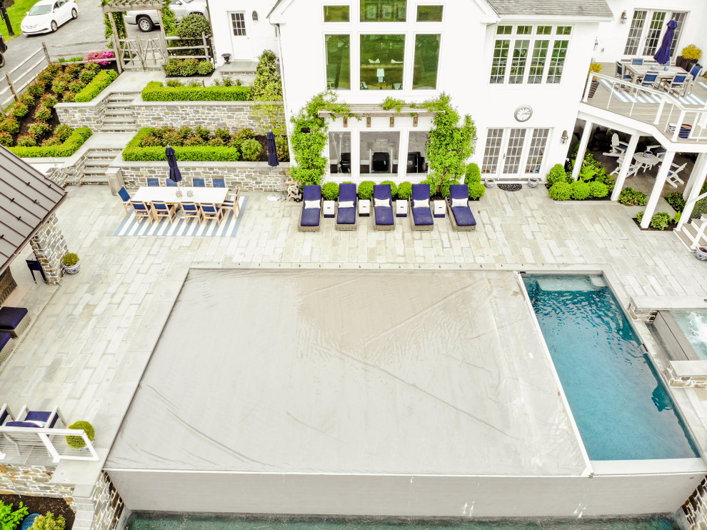Свежая идея для дизайна: большой прямоугольный бассейн-инфинити на заднем дворе в современном стиле с домиком у бассейна и покрытием из каменной брусчатки - отличное фото интерьера