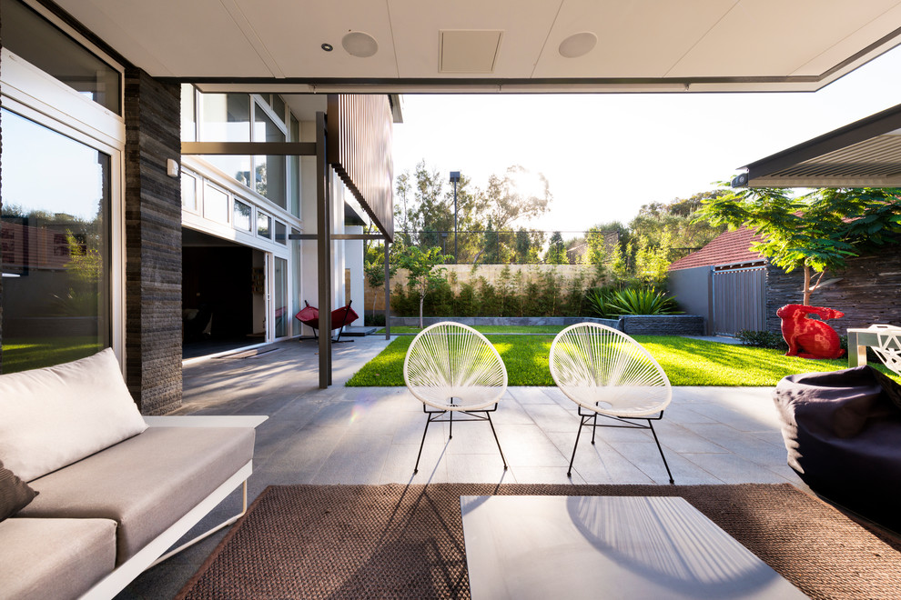 This is an example of a modern backyard patio in Perth with a roof extension.