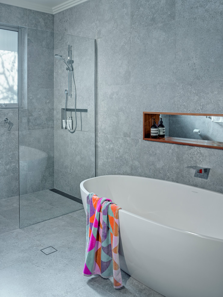 Inspiration for a large contemporary kids bathroom in Adelaide with an undermount sink, flat-panel cabinets, medium wood cabinets, engineered quartz benchtops, a freestanding tub, an open shower, a wall-mount toilet, gray tile, porcelain tile, grey walls and porcelain floors.