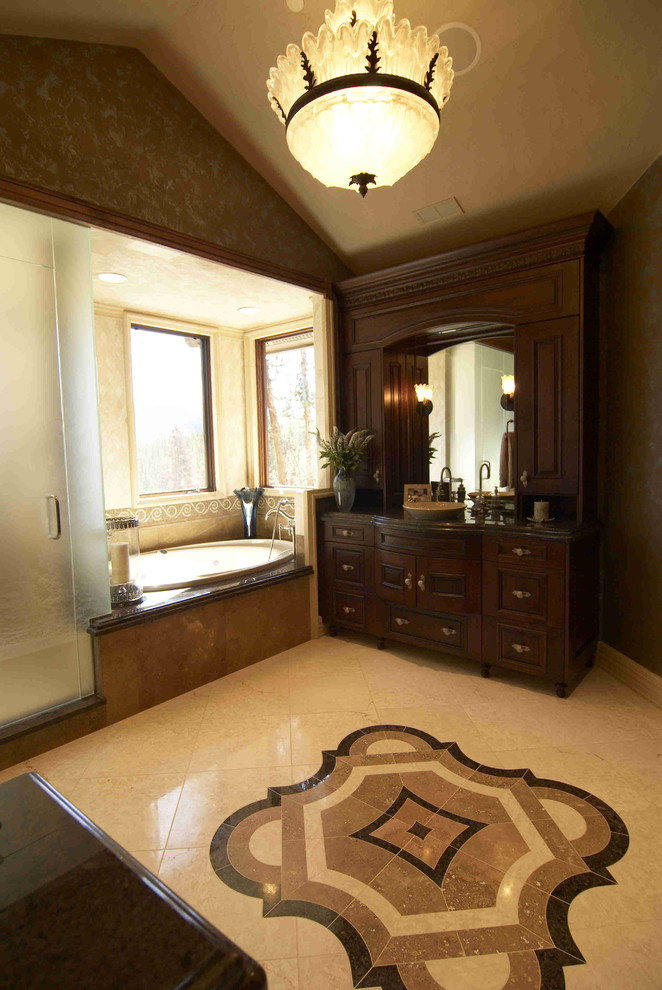 Photo of a country bathroom in Other with raised-panel cabinets, dark wood cabinets, a drop-in tub, beige tile, stone tile, marble floors, a vessel sink, granite benchtops and with a sauna.