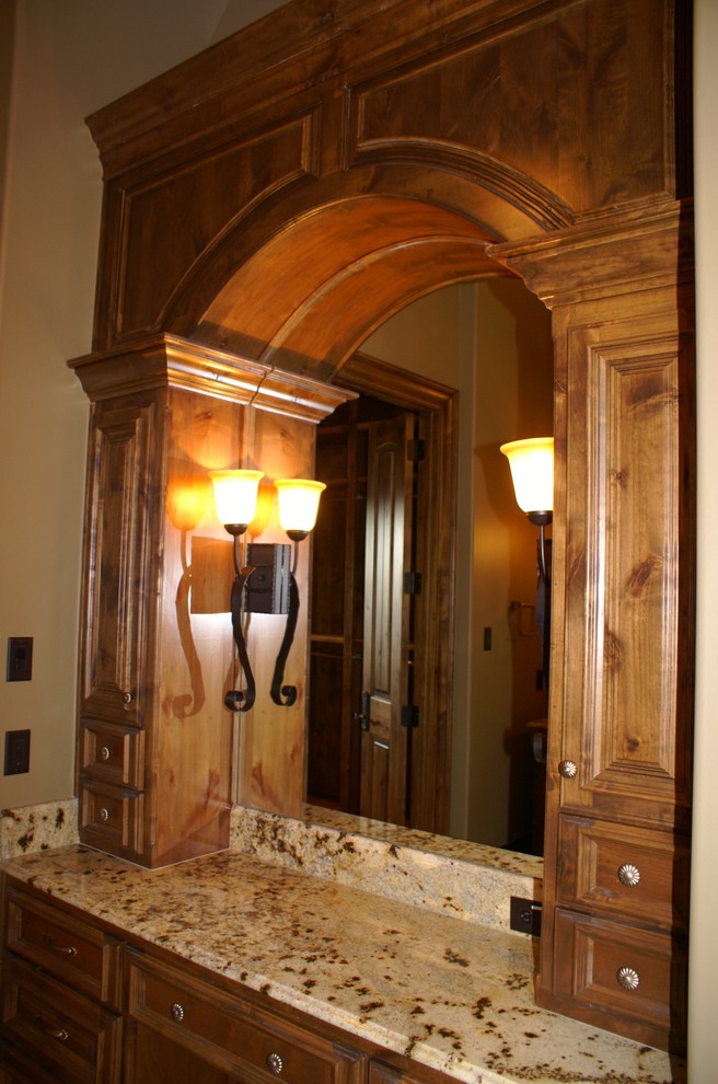Inspiration for a large mediterranean master bathroom in Dallas with raised-panel cabinets, dark wood cabinets, beige tile, stone tile, beige walls, terra-cotta floors, an undermount sink and granite benchtops.