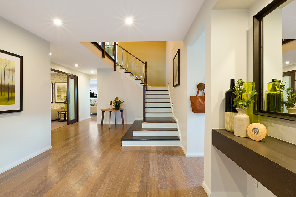Design ideas for a large contemporary foyer in Sydney with white walls, bamboo floors, a pivot front door and a medium wood front door.