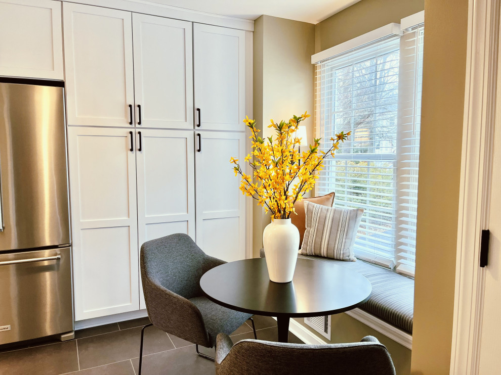 Eat-in kitchen - mid-sized transitional l-shaped vinyl floor and black floor eat-in kitchen idea with a farmhouse sink, shaker cabinets, white cabinets, quartz countertops, gray backsplash, ceramic backsplash, stainless steel appliances, a peninsula and gray countertops