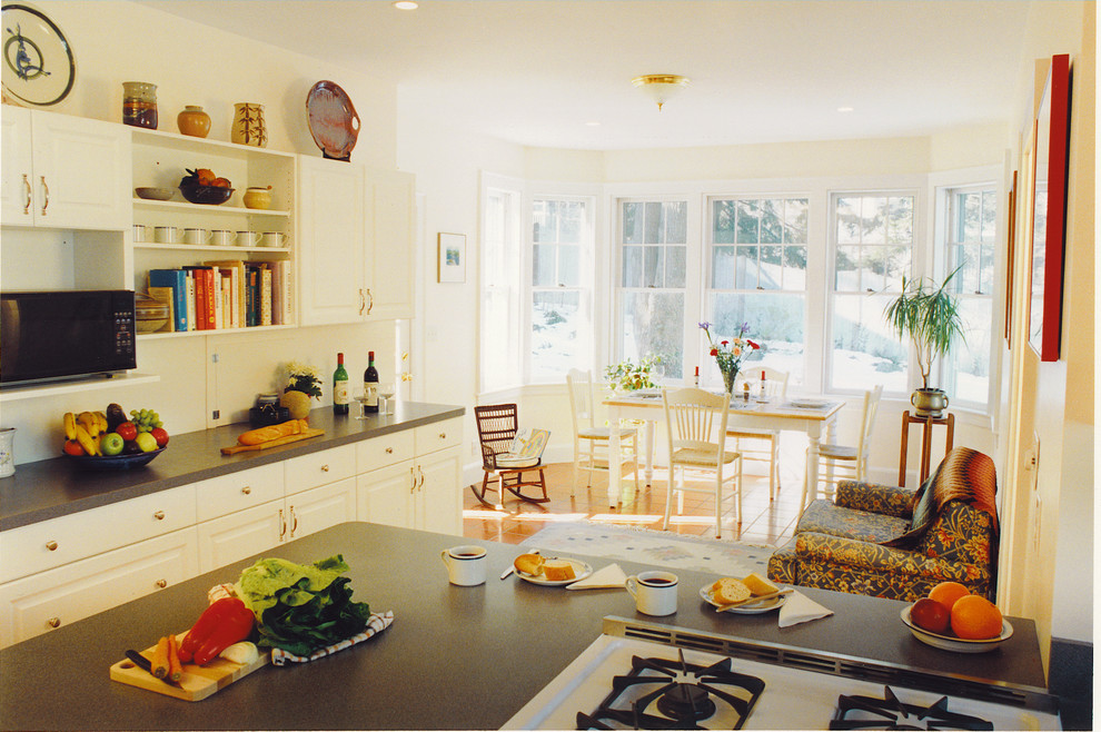 Photo of a large traditional l-shaped kitchen in Boston with a double-bowl sink, flat-panel cabinets, white cabinets, laminate benchtops, grey splashback, white appliances, ceramic floors and a peninsula.
