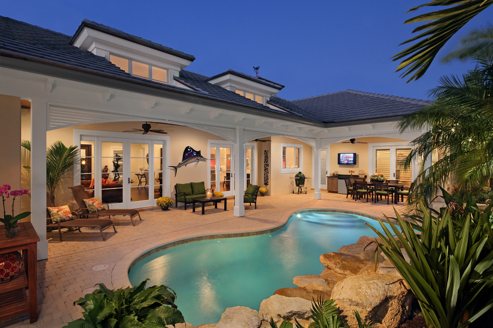 This is an example of a traditional courtyard custom-shaped pool in Miami.
