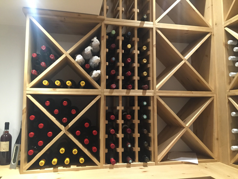 Mid-sized contemporary wine cellar in Oxfordshire with storage racks, light hardwood floors and brown floor.