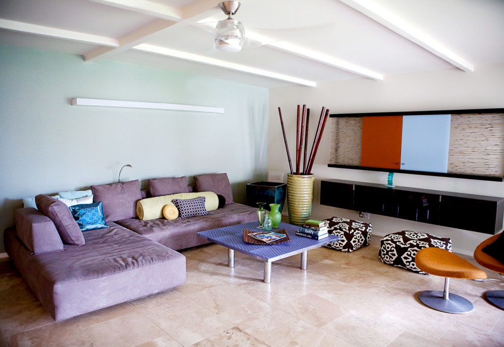 Cette image montre un très grand salon minimaliste ouvert avec un bar de salon, un mur bleu, un sol en travertin, un manteau de cheminée en plâtre, un téléviseur dissimulé, un sol beige et poutres apparentes.