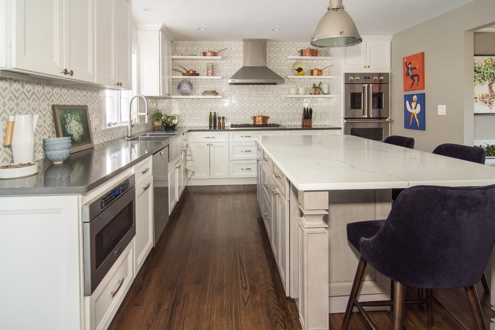 Inspiration for a large transitional l-shaped dark wood floor and brown floor eat-in kitchen remodel in Newark with a double-bowl sink, multicolored backsplash, an island, gray countertops, recessed-panel cabinets, white cabinets, quartz countertops, marble backsplash and stainless steel appliances