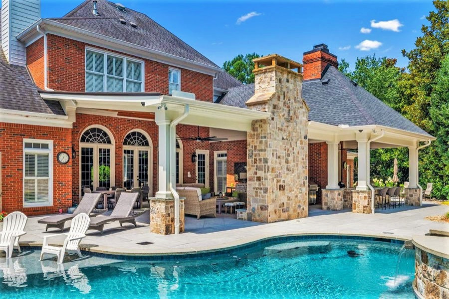 Immagine di una grande piscina naturale tradizionale personalizzata dietro casa con paesaggistica bordo piscina e pavimentazioni in pietra naturale