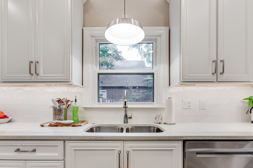 Eat-in kitchen - mid-sized transitional u-shaped medium tone wood floor and brown floor eat-in kitchen idea in Birmingham with a double-bowl sink, recessed-panel cabinets, white cabinets, quartz countertops, white backsplash, subway tile backsplash, stainless steel appliances, a peninsula and white countertops