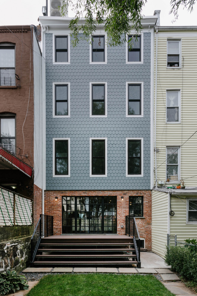 Photo of a contemporary blue townhouse exterior in New York with four or more storeys.