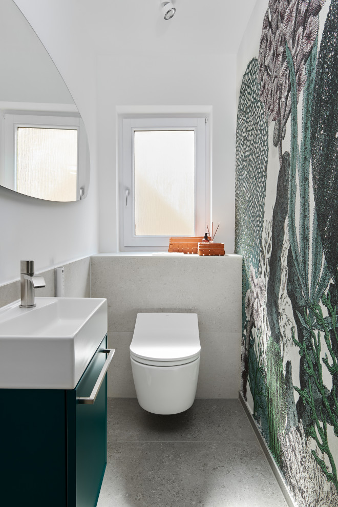 Gästetoilette mit flächenbündigen Schrankfronten, grünen Schränken, Wandtoilette, grauen Fliesen, weißer Wandfarbe und grauem Boden in Stuttgart