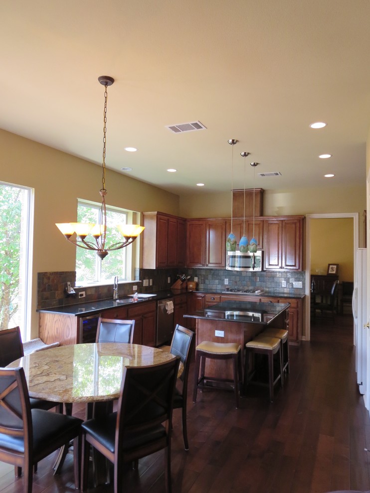 Mid-sized transitional u-shaped medium tone wood floor and brown floor eat-in kitchen photo in Austin with an undermount sink, raised-panel cabinets, medium tone wood cabinets, granite countertops, multicolored backsplash, slate backsplash, white appliances and an island