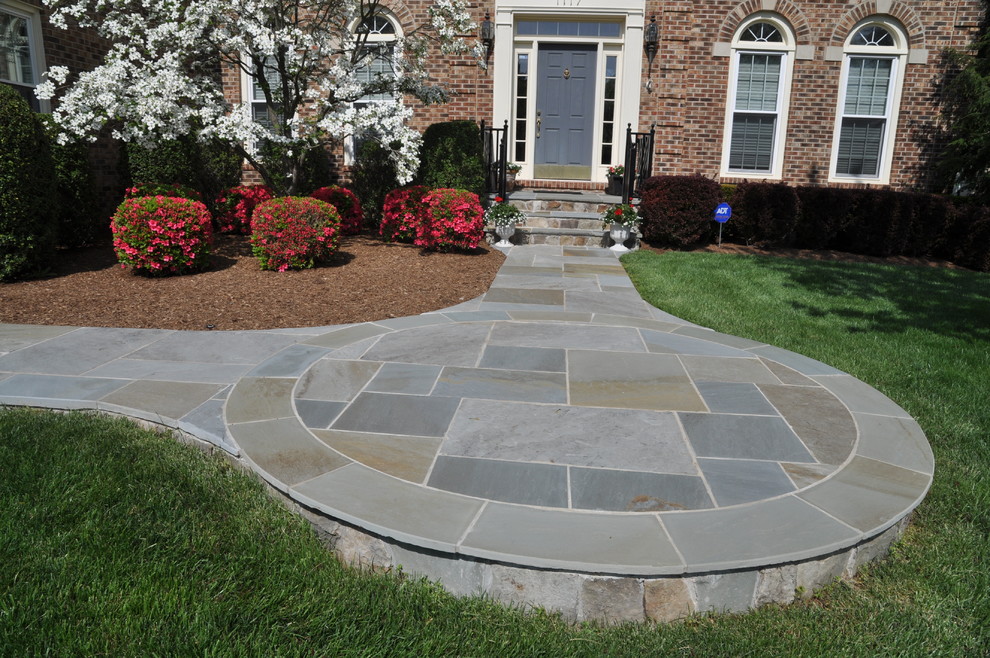 Photo of a mid-sized traditional front yard full sun formal garden for fall in DC Metro with a garden path and natural stone pavers.