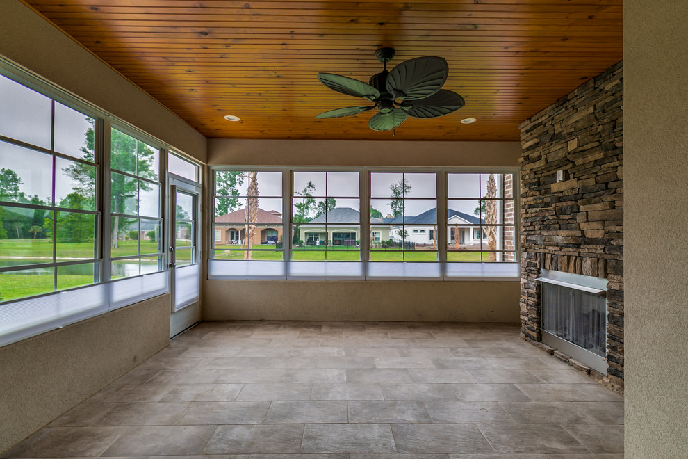 Large mountain style ceramic tile and beige floor sunroom photo with a standard fireplace, a stone fireplace and a standard ceiling