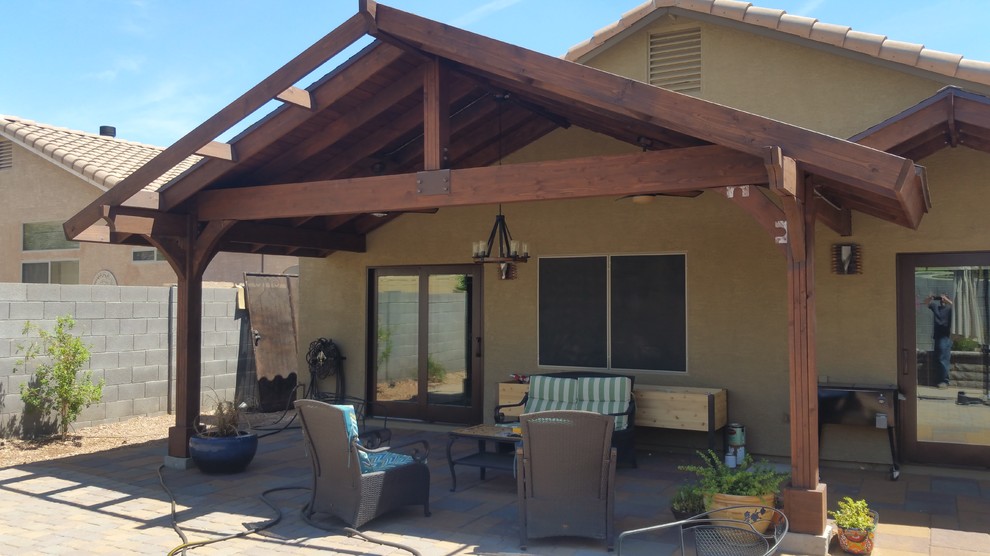 This is an example of a mid-sized traditional backyard patio in Phoenix with brick pavers and a pergola.