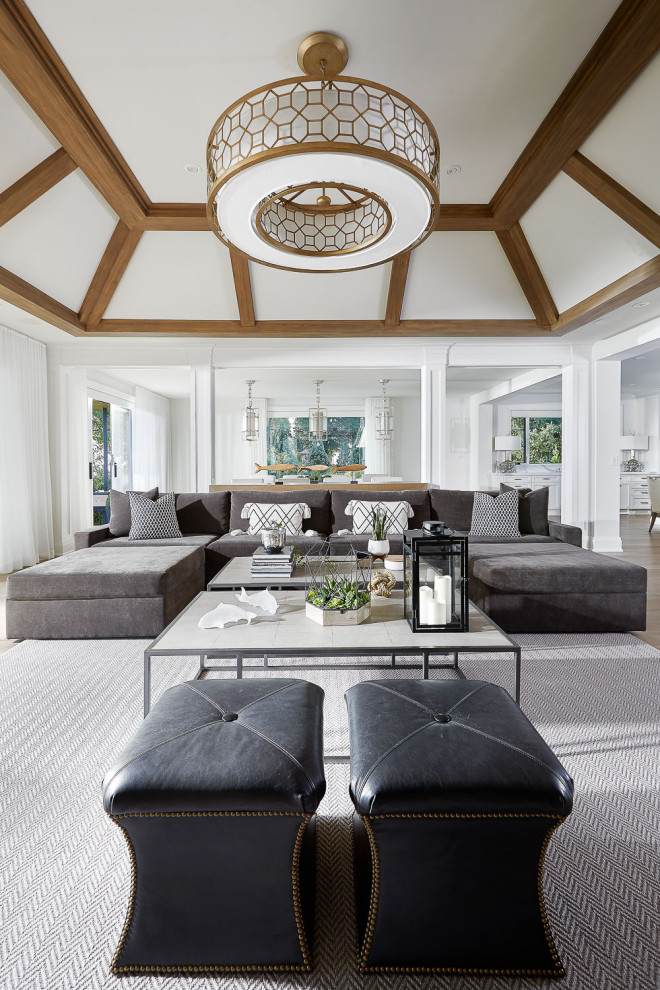 Idee per un ampio soggiorno boho chic aperto con pareti bianche, pavimento in legno massello medio e travi a vista