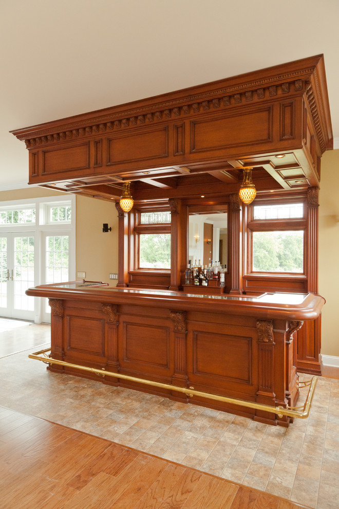 Inspiration for a large single-wall seated home bar in New York with raised-panel cabinets, medium wood cabinets, wood benchtops, no sink, grey splashback, mirror splashback, laminate floors, yellow floor and yellow benchtop.