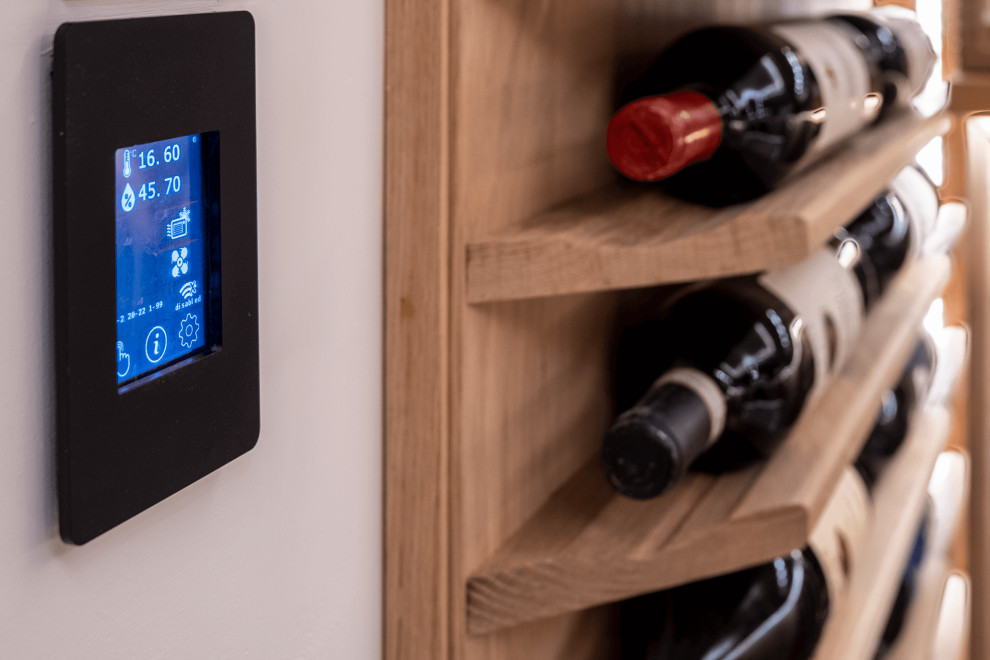 This is an example of a medium sized modern wine cellar in Surrey with marble flooring, storage racks and grey floors.