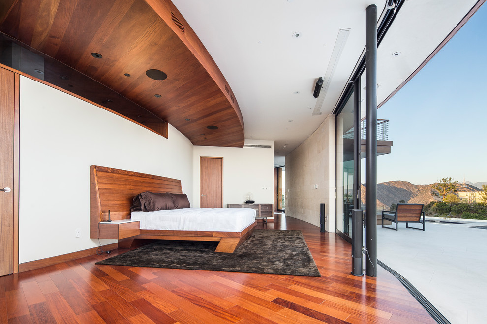 This is an example of a large contemporary master bedroom in Los Angeles with medium hardwood floors, no fireplace and white walls.