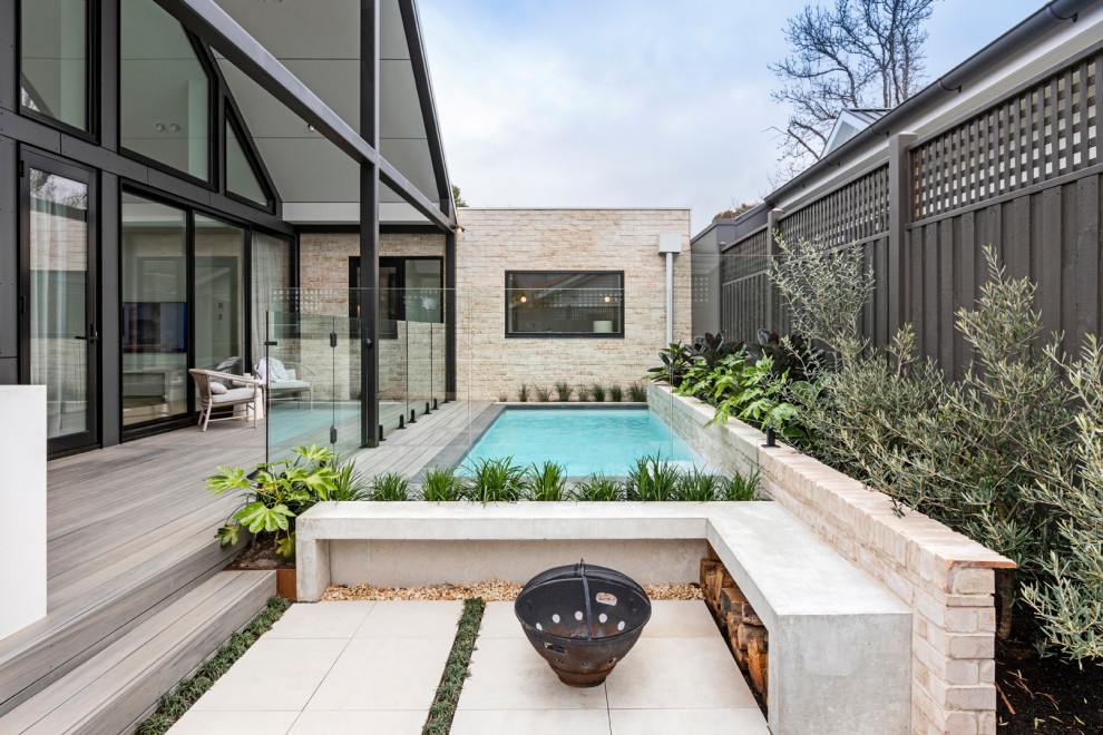 Aménagement d'un petit piscine avec aménagement paysager arrière contemporain rectangle avec une terrasse en bois.