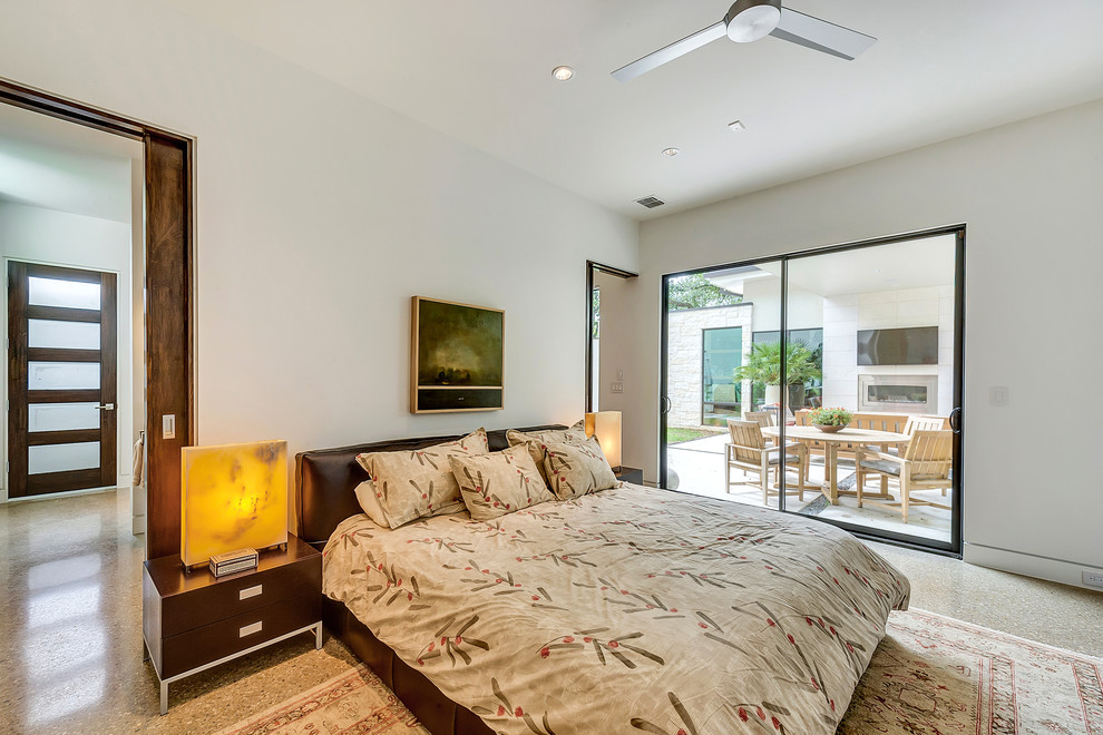 This is an example of a large modern master bedroom in Dallas with white walls and concrete floors.