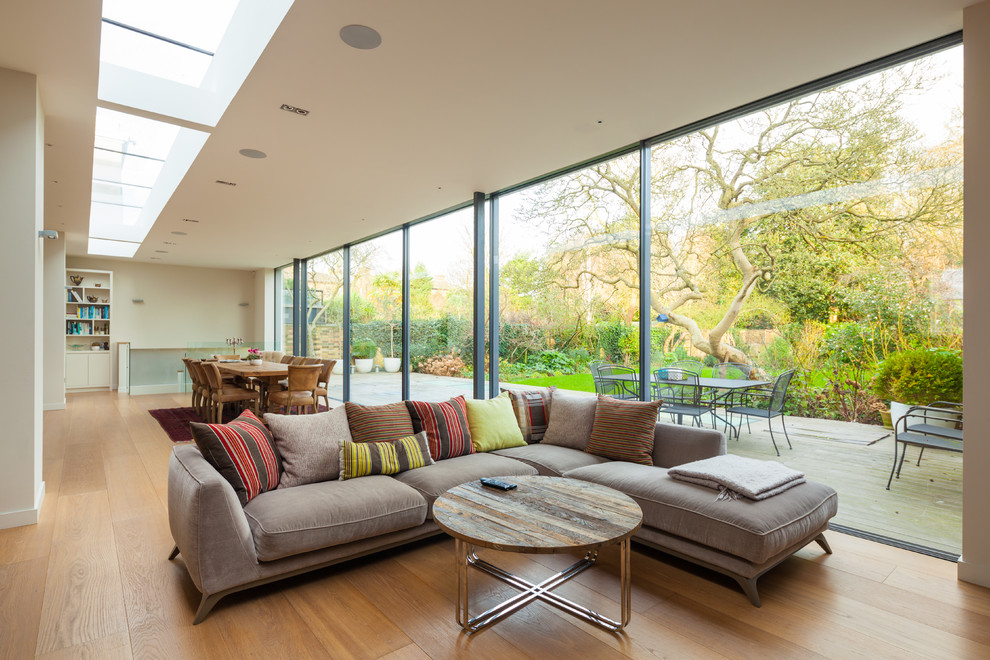 This is an example of a transitional living room in London with medium hardwood floors.