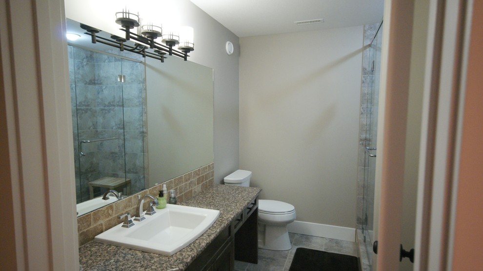 This is an example of a small arts and crafts bathroom in Calgary with recessed-panel cabinets, dark wood cabinets, beige tile and terra-cotta tile.
