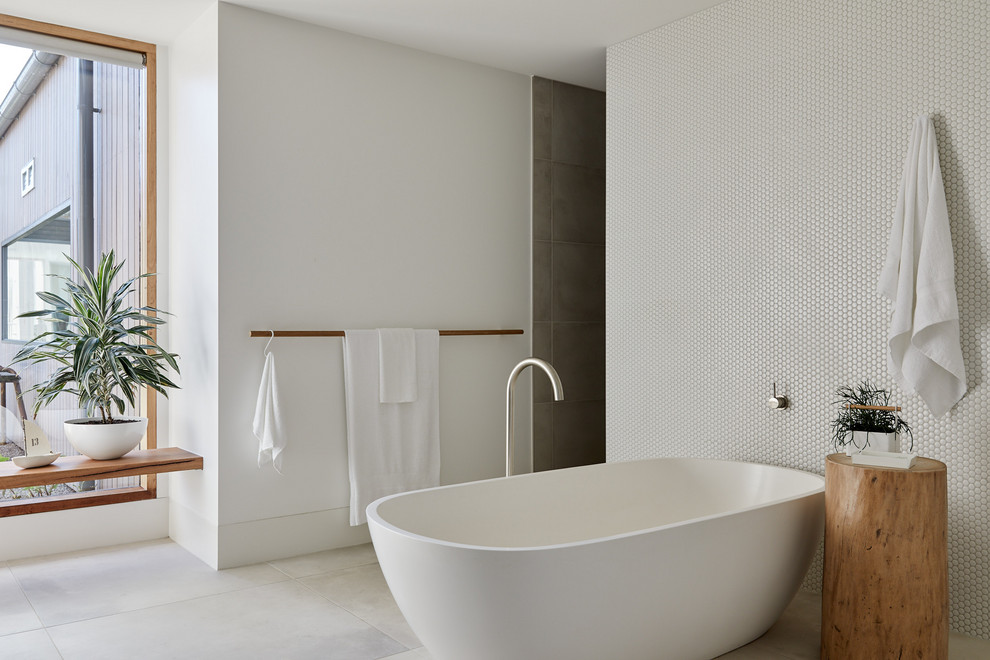 This is an example of a scandinavian master bathroom in Melbourne with a freestanding tub, white tile, mosaic tile, white walls and grey floor.