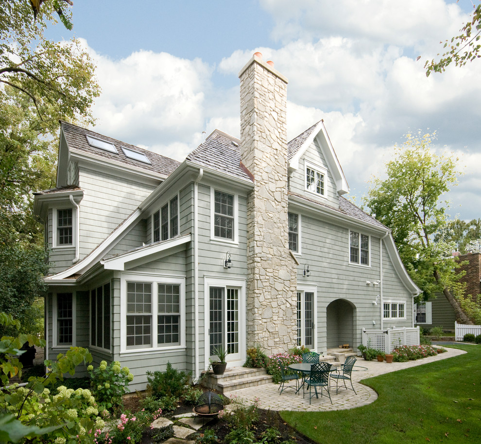 Photo of a mid-sized traditional two-storey grey exterior in Chicago with vinyl siding and a gable roof.