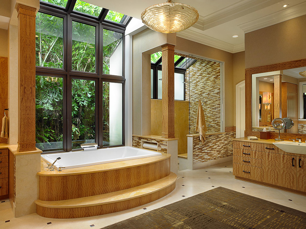 Photo of an expansive mediterranean master bathroom in Miami with a drop-in sink, flat-panel cabinets, medium wood cabinets, quartzite benchtops, a drop-in tub, a corner shower, multi-coloured tile, mosaic tile, beige walls and marble floors.