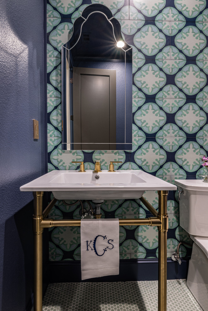 Powder room - small transitional multicolored tile and wood-look tile porcelain tile and green floor powder room idea in Dallas with a one-piece toilet, blue walls, a console sink and a freestanding vanity